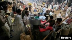 A man sells food at a fruit and vegetables market in Lahore November 12, 2012. REUTERS/Mani Rana (PAKISTAN - Tags: SOCIETY BUSINESS AGRICULTURE FOOD) - RTR3AB6X