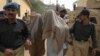 The two suspected al-Qaida members, Mohammed Anwar and Habibullah, with their faces covered, are brought to a court in Karachi, Pakistan, in an armored personnel carrier escorted by police and paramilitary troops Saturday, May 3, 2003 . The Court has hand