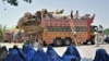 TO GO WITH Afghanistan-unrest-Pakistan-refugees,FOCUS by Joris Fioriti(FILES) In this photograph taken on June 19, 2012, Afghan refugees sit in front of trucks at The United Nations High Commissioner for Refugees (UNHCR) registration centre on the outskir