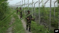 India’s Border Security Force soldiers patrol near the India-Pakistan international border fencing at Garkhal in Akhnoor, west of Jammu, India, Aug. 13, 2019. 