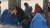 Afghan refugee families sit outside the government registration office preparing to leave for their homeland, in Peshawar, Pakistan, March 14, 2017.