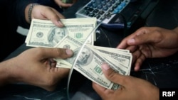 A Pakistani currency dealer counts U.S. dollar notes at his shop in Karachi October 23, 2008. Pakistan has not formally asked for a facility from the International Monetary Fund (IMF), the prime minister's top adviser on economic affairs said on Thursday,