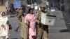 An army soldier helps polling officials deliver election material to a polling station ahead of the by-election in Lahore, Pakistan October 10, 2015. The by-election poll will be held on Sunday. REUTERS/Mohsin Raza - GF10000239830