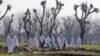 Women walk near the site of an attack on the outskirts of Peshawar, Pakistan, Feb. 12, 2014. Militants killed several members of an anti-Taliban militia on Wednesday in Pakistan's northwestern city of Peshawar, police said. 